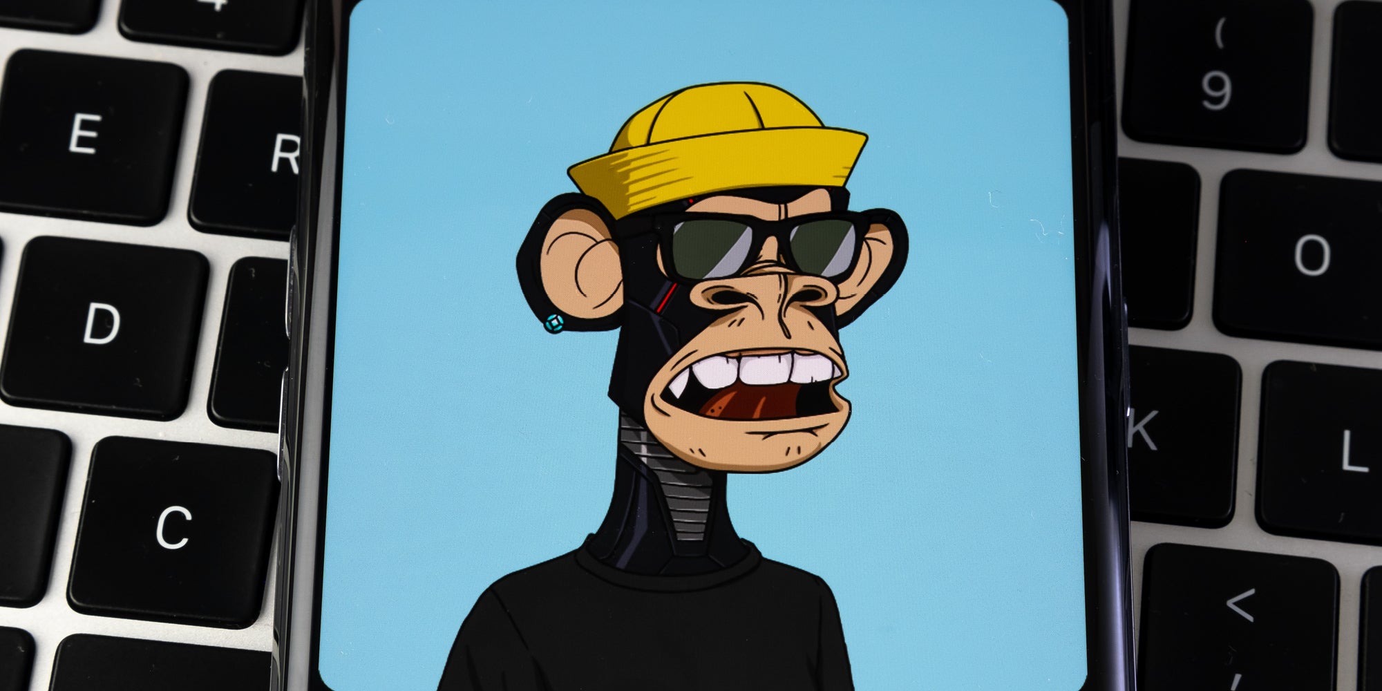 NFT blog banner Bored Ape Yacht Club NFT on a phone screen on top of a keyboard Credit Ascannio